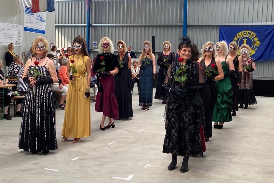 Die Models präsentieren Abendgarderobe, jeweils mit einer roten Rose in der Hand.