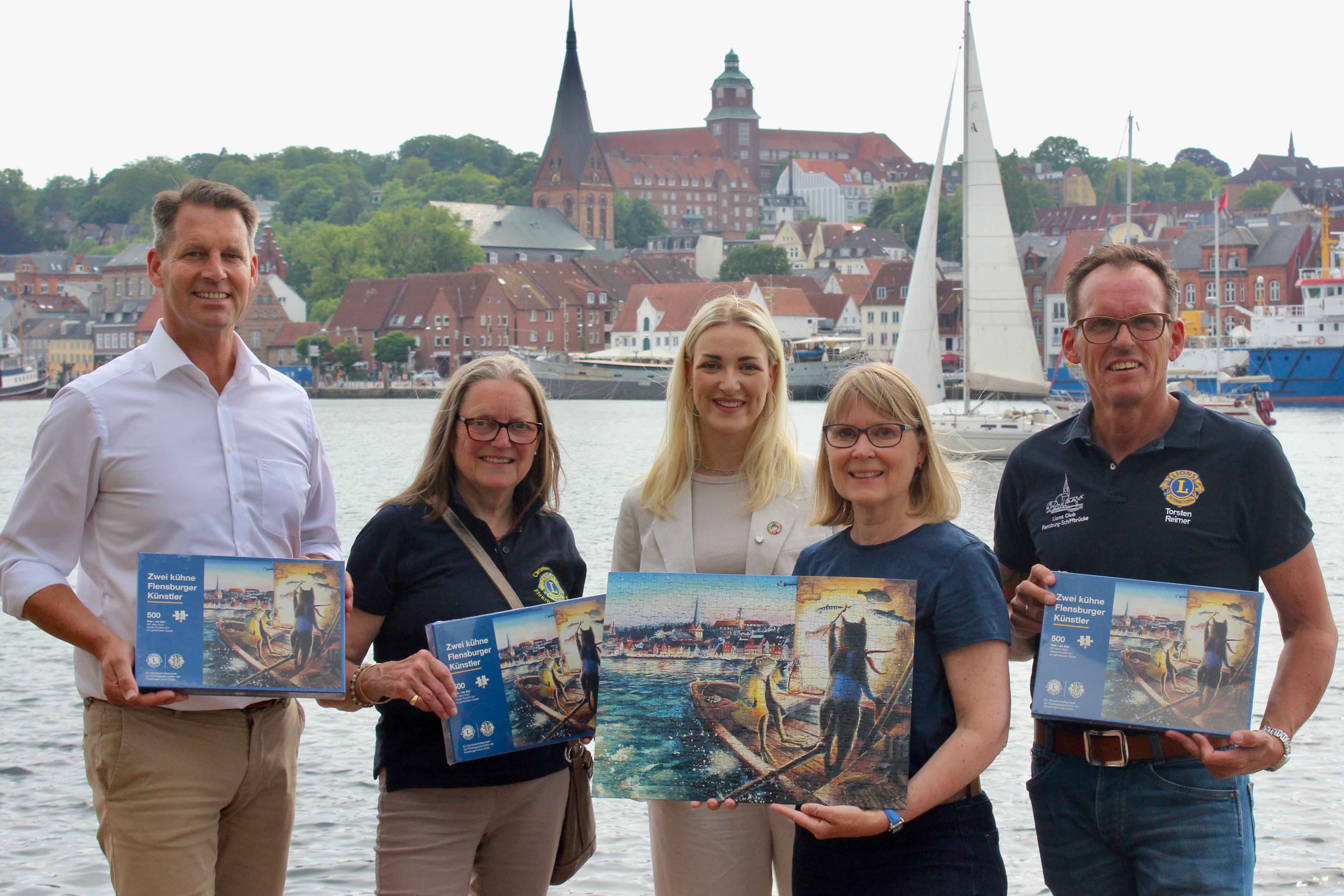 Die Präsident innen der Flensburger Lions und Leo-Clubs präsentieren das Lions-Puzzle am Flensburger Hafen