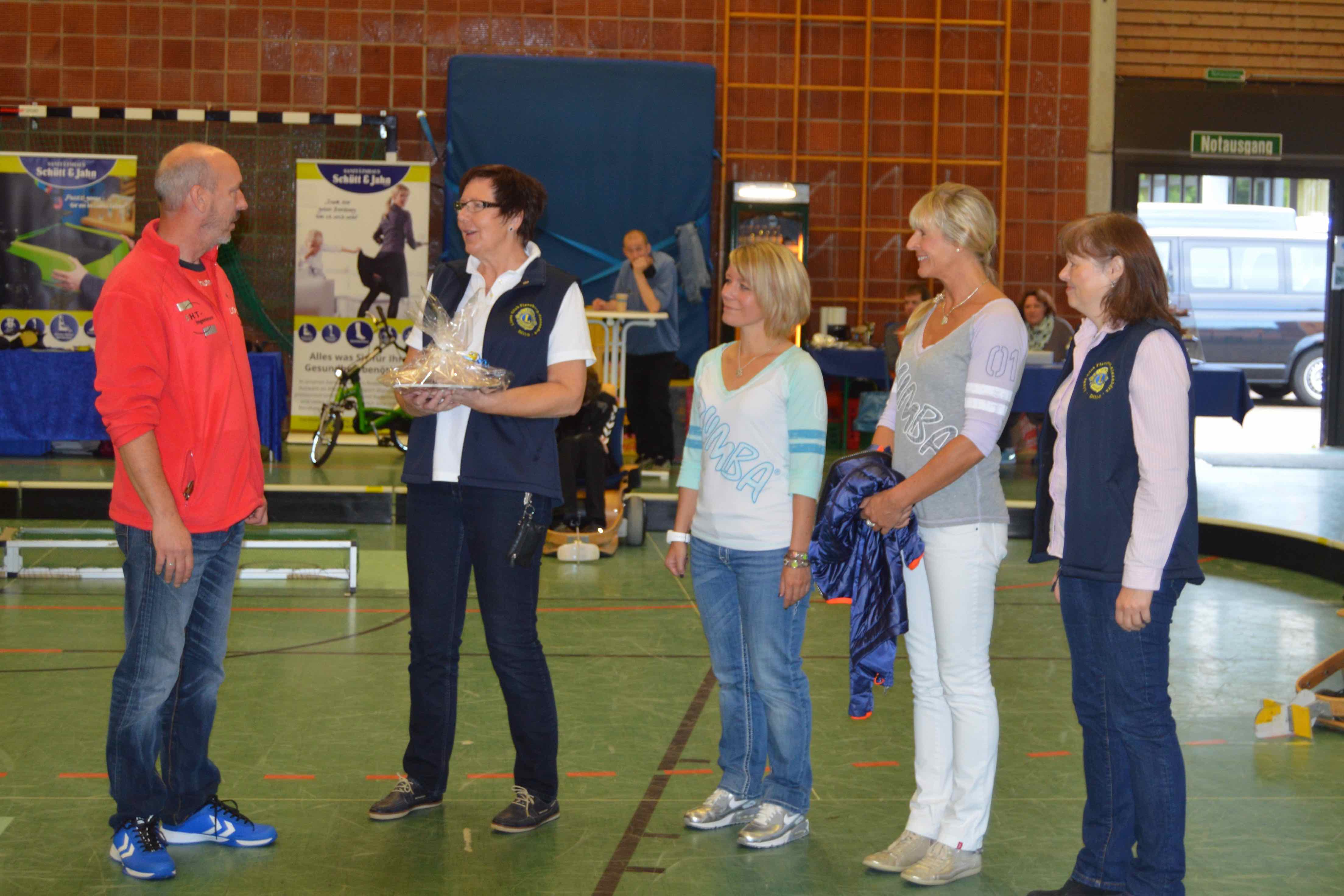 Präsidentin Anke Edelhoff überreicht zusammen mit den Akteuren der Benefiz-Zumba-Veranstaltung den Spendencheck in der Sporthalle der Flensburg LIONS.