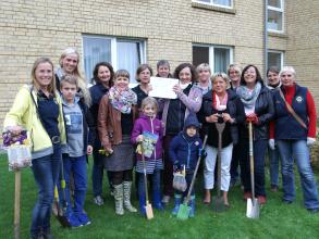 Eine Gruppe der Alexandras mit ihren Kindern bei einer Blumenzwiebel-Pflanzaktion