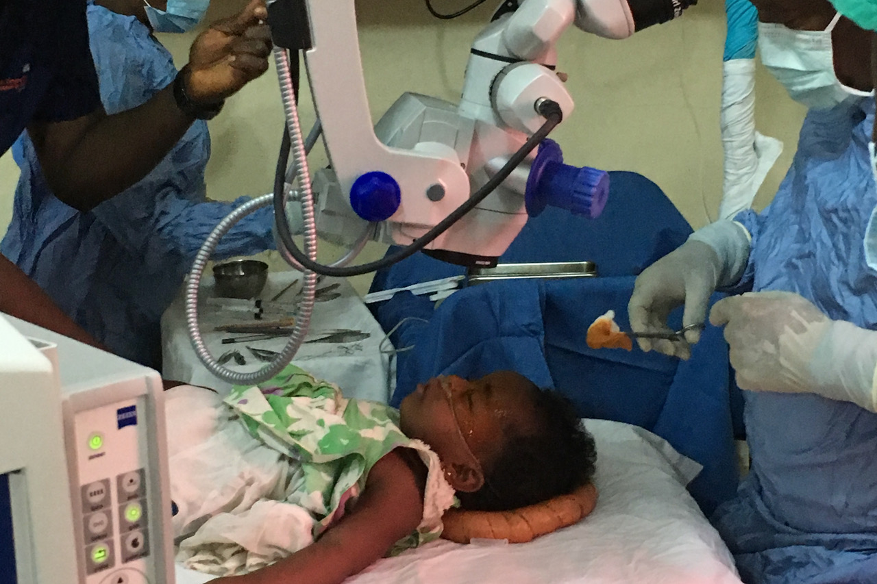 Ein Mädchen wird auf einem OP-Tisch liegend am Auge in Sierra Leone operiert – Foto 1
