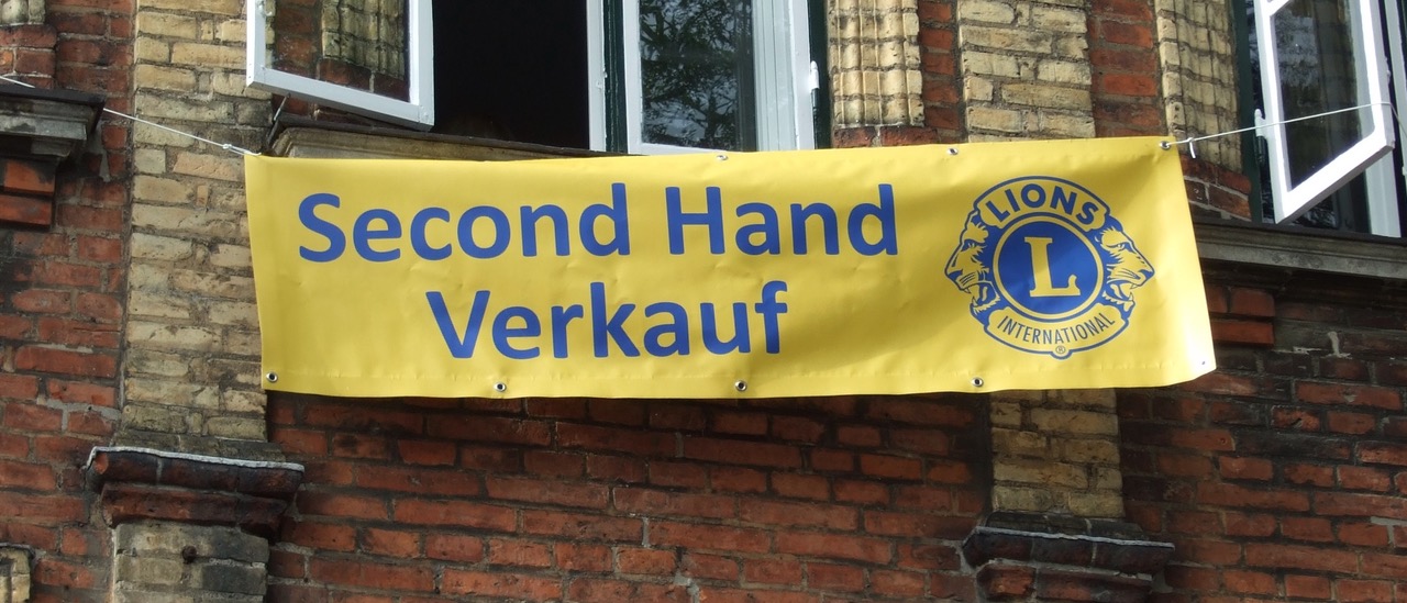 Gelbes Banner des Second-Hand-Verkaufs draußen am Gebäude