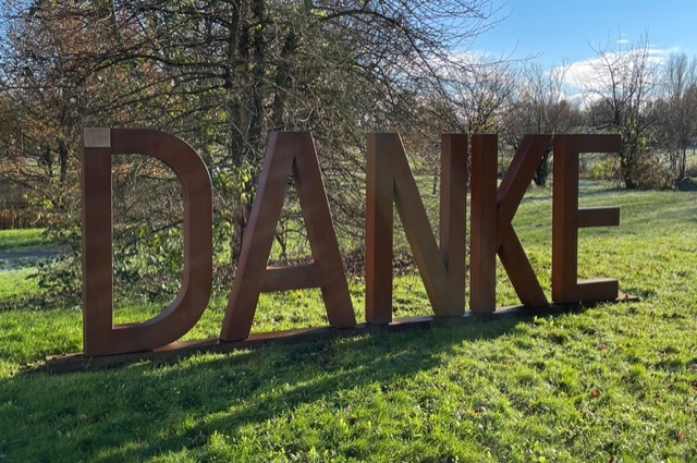 Fünf große Buchstaben stehen in der Landschaft: D, A, N, K und E bilden zusammen das Wort Danke
